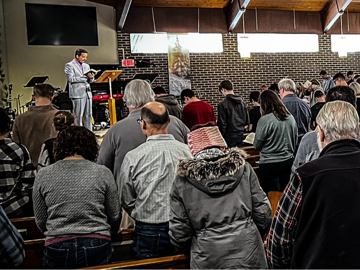 Pastor preaching from the Bible during a Sunday service at Dearborn Christian Fellowship